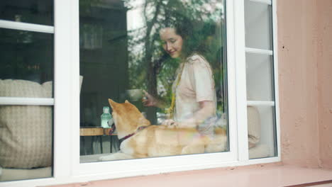 woman enjoying coffee with her dog by the window