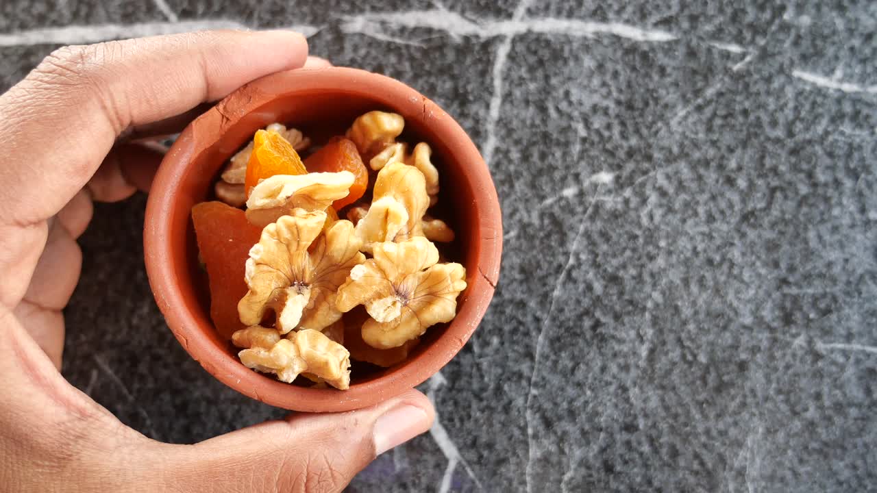 Closeup of a bowl with walnuts and dried apricots