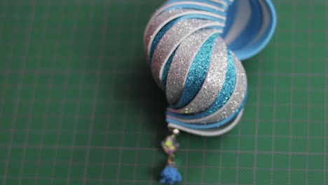 blue and silver glitter foami christmas ornament on green cutting mat