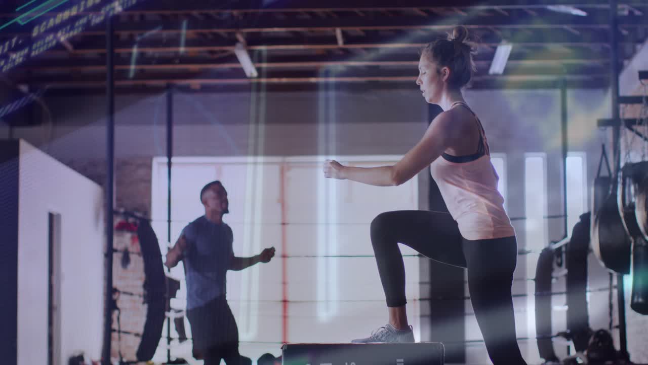 Upon man starting rope skipping and woman stepping onto plyo box performing jumps for gym training