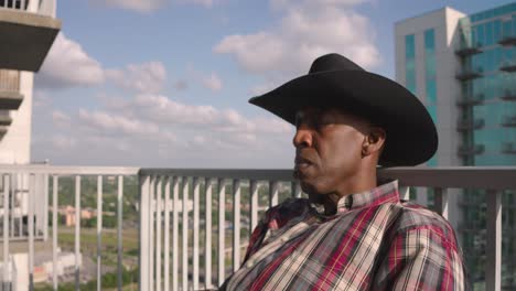 hombre negro con sombrero de vaquero duerme en el balcón