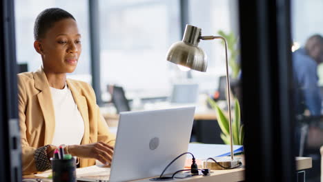 retrato de una mujer de negocios afroamericana usando una computadora portátil en la oficina, cámara lenta, espacio de copia