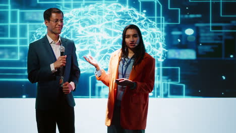 Presenter and guest talking at AI summit exploring latest tech developments