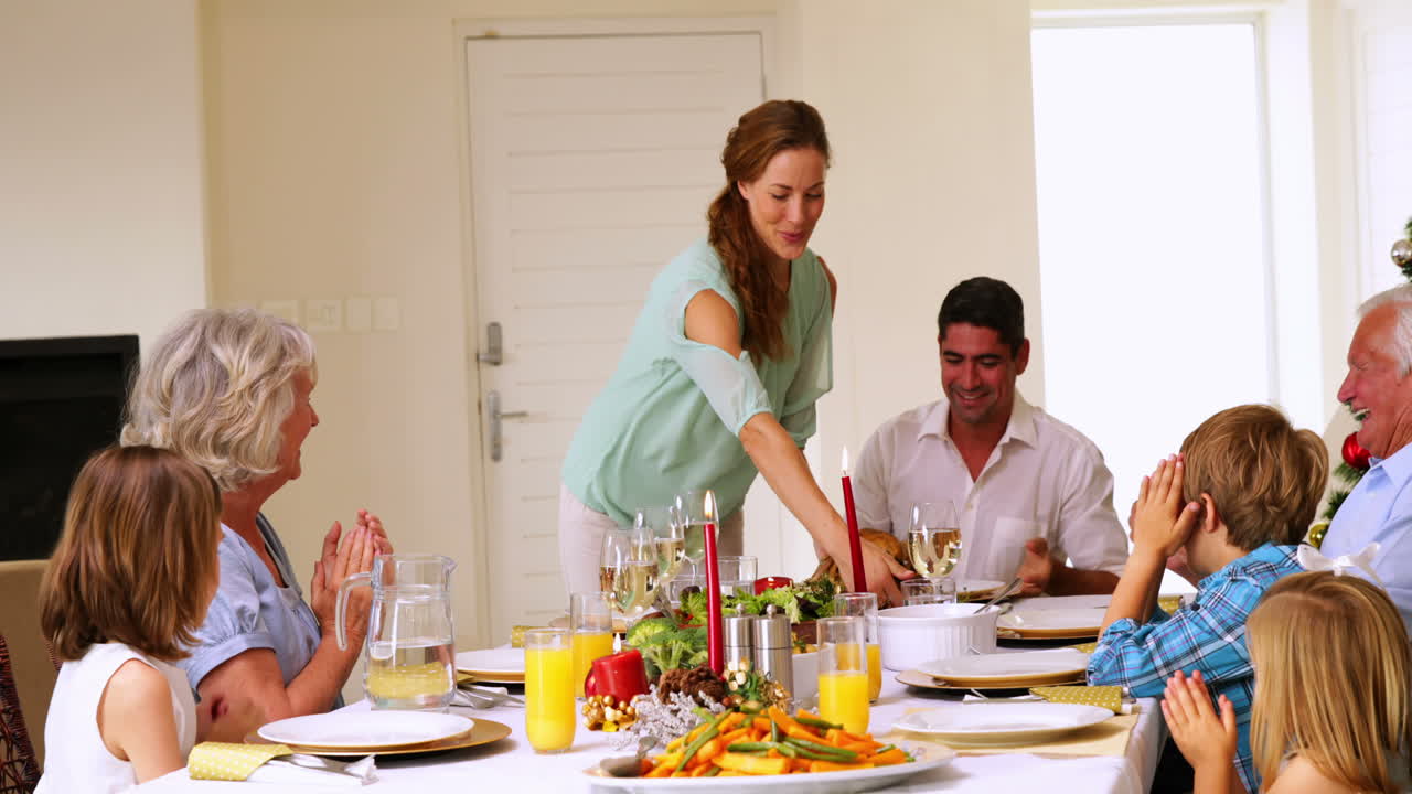 madre trayendo pavo a la mesa de la cena en navidad