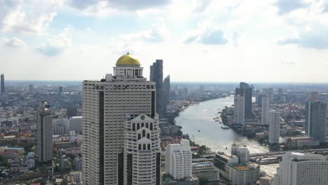 aerial view of the iconic lebua hotel in bangkok with panoramic chao phraya river backdrop on a clear day
