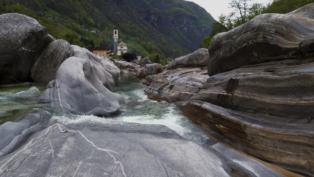 pan a lo largo de las aguas que fluyen suavizando rocas y piedras a la capilla en lavertezzo suiza