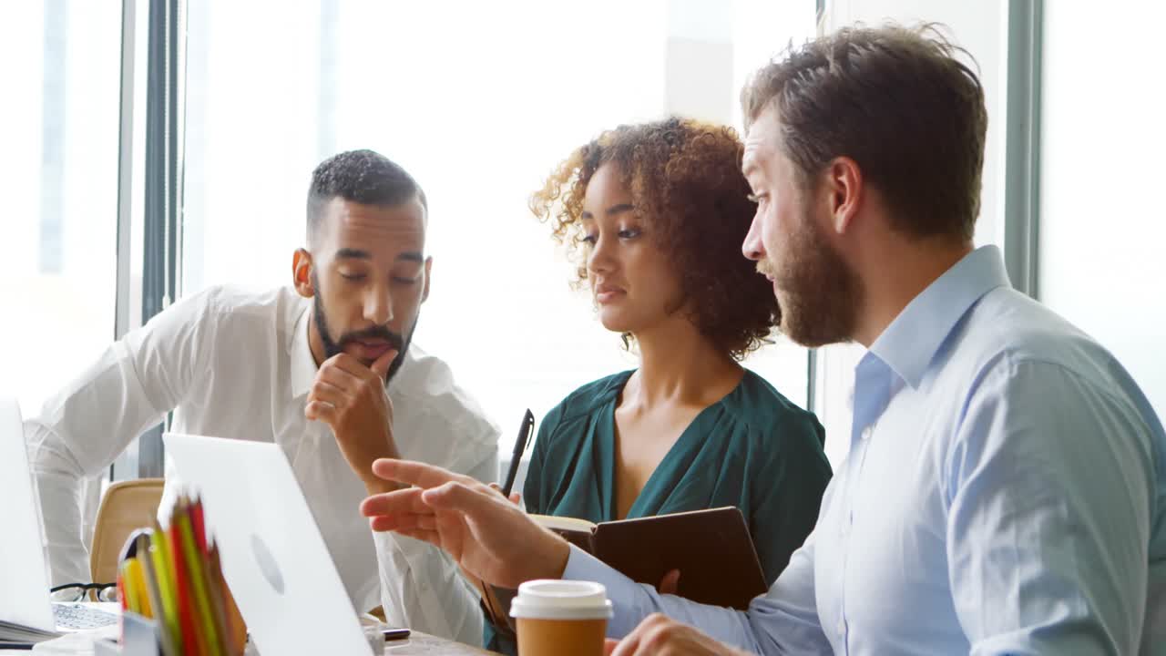 Architects discussing over laptop at desk 4k