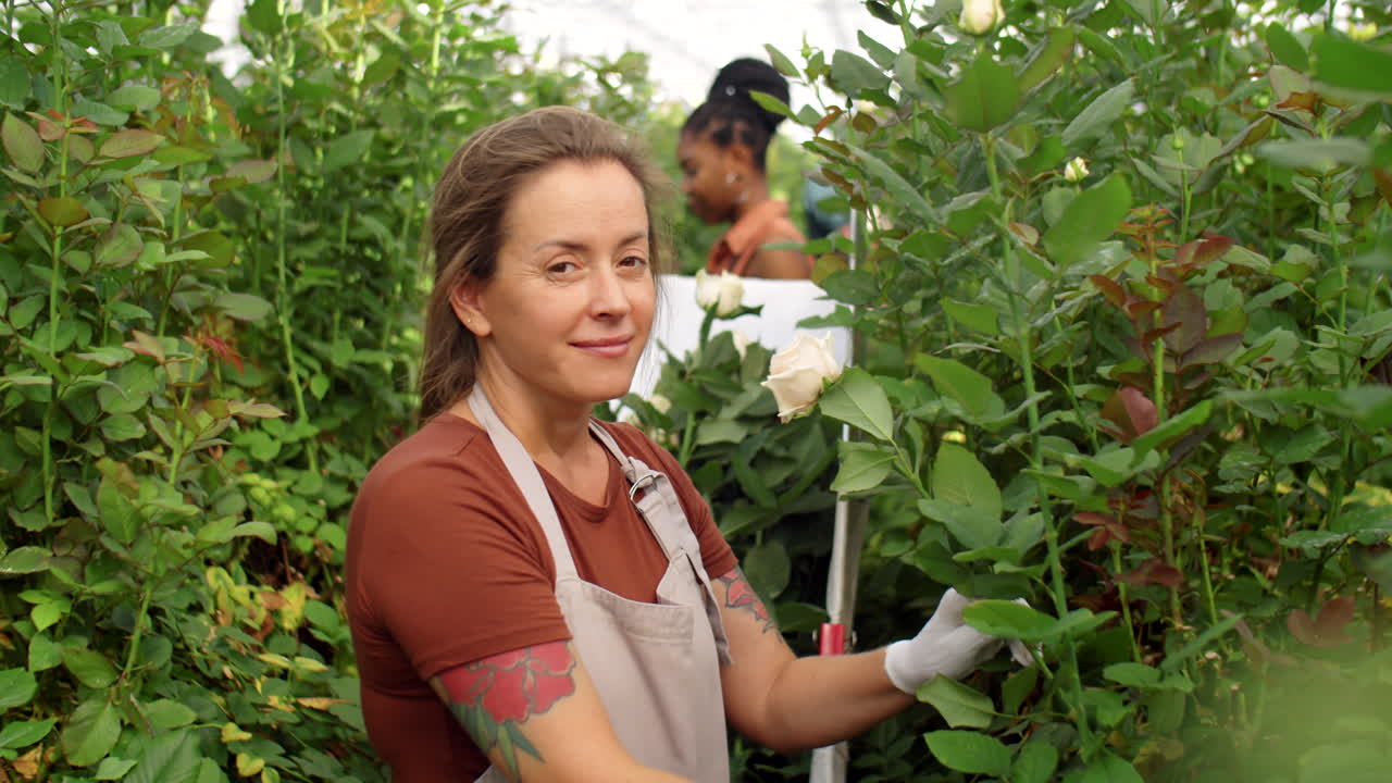 retrato de una mujer alegre trabajando en un invernadero de flores