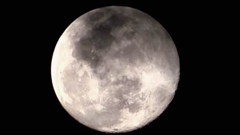 close up video of the full moon standing directly below the big and prominent planet we see every night during the early hours of the morning on a grey and overcast day in the south of england