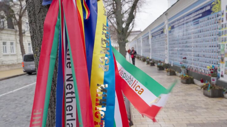 Bandiere celebrative in tessuto di poliestere vivaci e luminose sventolano al vento presso il Muro della Memoria a Kiev, Ucraina.