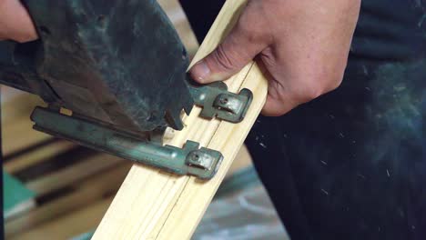hombre usando sierra para cortar madera