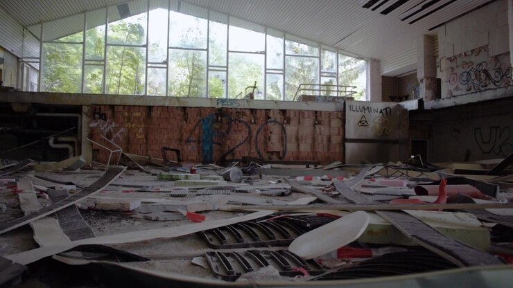 Destroyed abandoned Swimming Pool with a lot of Stuff on the Ground