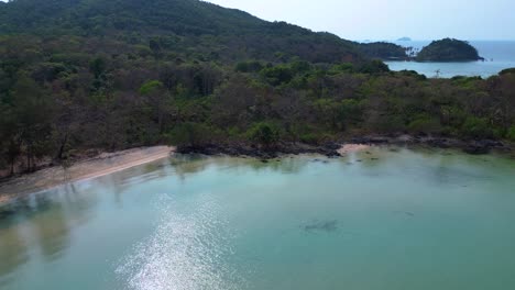 tropical vegetation meeting crystal clear water on natural beach koh mak island, thailand. beautiful aerial view flight wide orbit overview drone