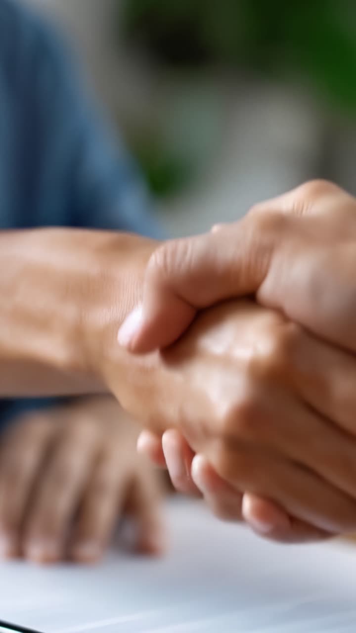 A Close-Up of Two People Shaking Hands in a Professional Setting to Establish Trust and Cooperation, Highlighting the Importance of Agreements and Partnerships
