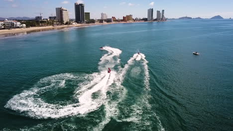 Tres-Motos-De-Agua-Compitiendo-En-Una-Carrera-En-El-Mar-Cerca-De-La-Playa,-Mazatlan