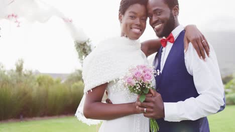 Portrait-of-happy-african-american-couple-embracing-during-wedding