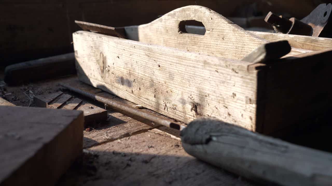 Old wooden toolbox on worktop illuminated by sunlight