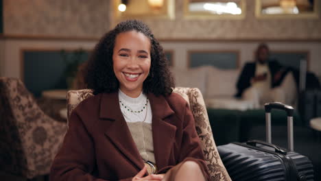 woman smiling in a hotel lobby with her luggage