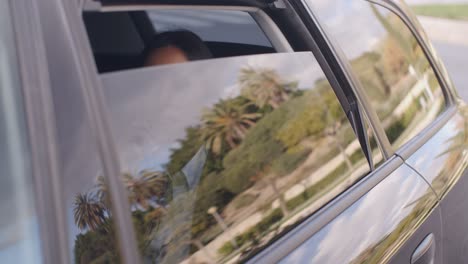 Curious-business-woman-on-teléfono-looking-from-car