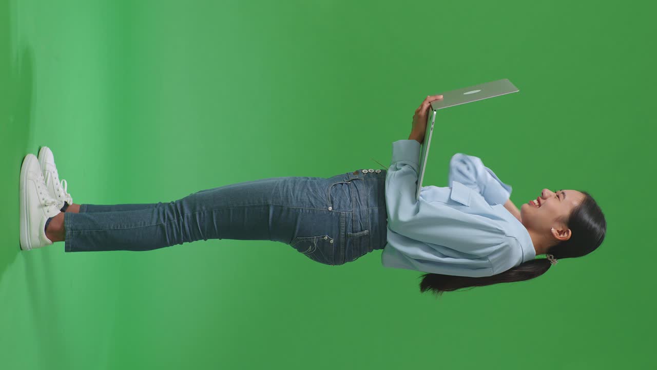 mujer celebrando con una computadora portátil en la pantalla verde