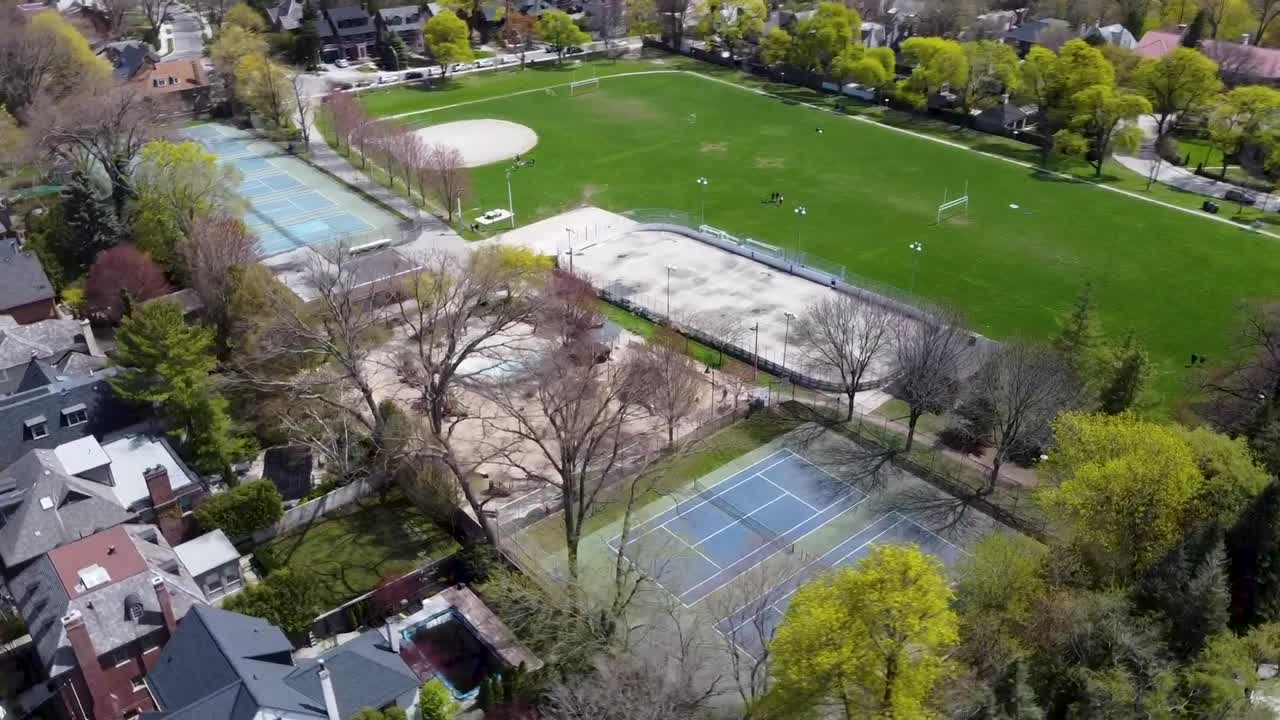 drone dando vueltas sobre el diamante de béisbol y las canchas de tenis en el parque de toronto