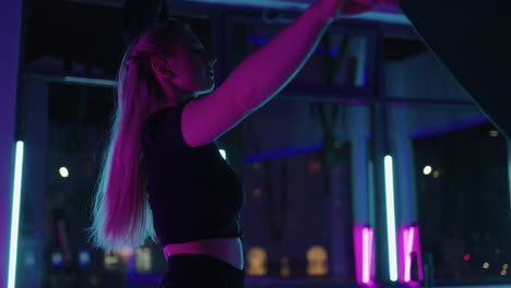 una mujer joven sonriente practicando en un columpio de estiramiento aéreo. ejercicios de yoga de vuelo aéreo practicando en una hamaca verde en un club de fitness