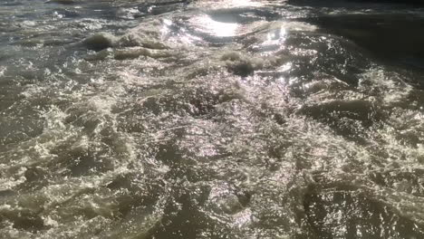 vista en cámara lenta extrema del agua brillante de los reflejos del río en un día soleado