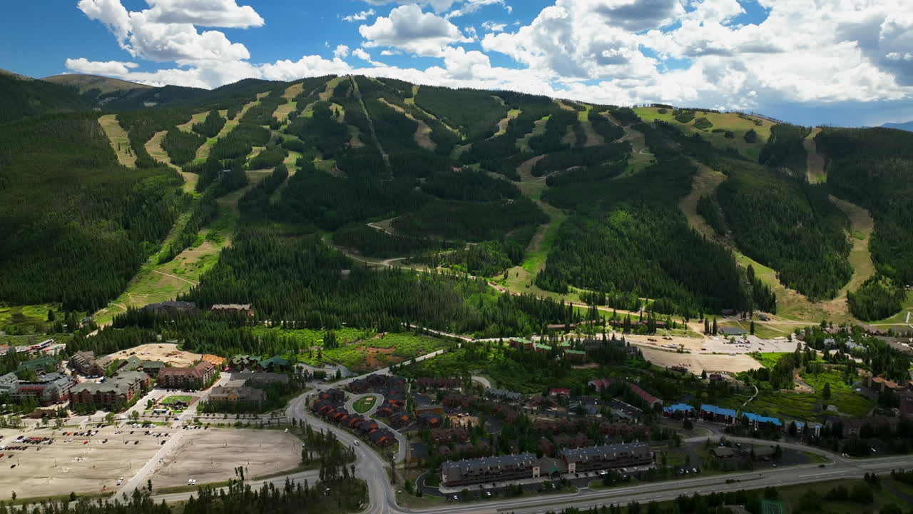 verano keystone breckenridge colorado vail resort paso épico entrada esquí snowboard bicicleta ciclismo motociclista góndola corre aéreo cinematográfico dron de alta altitud cielo azul de la tarde nubes lentamente movimiento hacia atrás