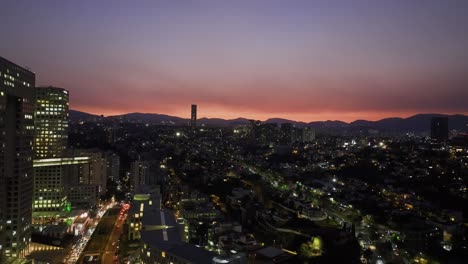 Drone-shot-revealing-the-towers-of-Arcos-Bosques,-dramatic-evening-in-Santa-Fe,-Mexico