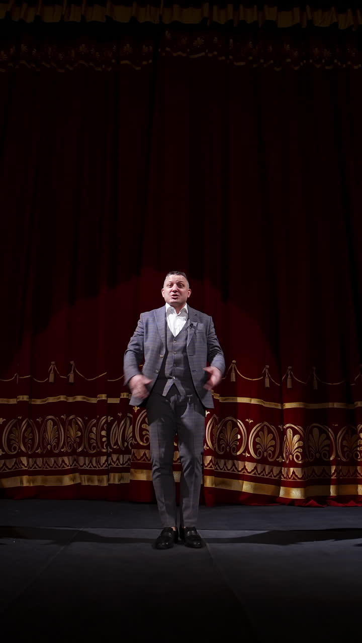 Showman dances on a stage. Senior male entertainer, presenter or actor on stage. Selective focus on a male in suit. Vertical video