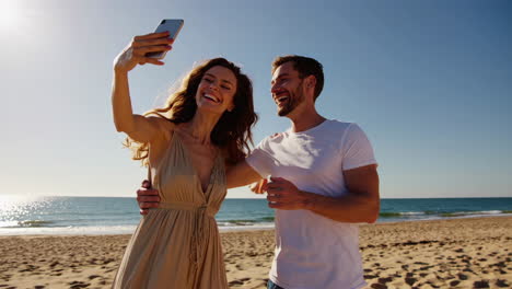 happy couple taking a selfie on a sunny beach