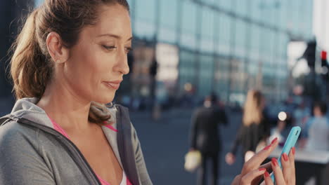 retrato en cámara lenta de una hermosa mujer de fitness feliz usando un teléfono inteligente