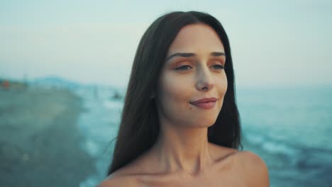 The-camera-captures-the-face-of-young-girl-walking-on-the-beach-at-sunset