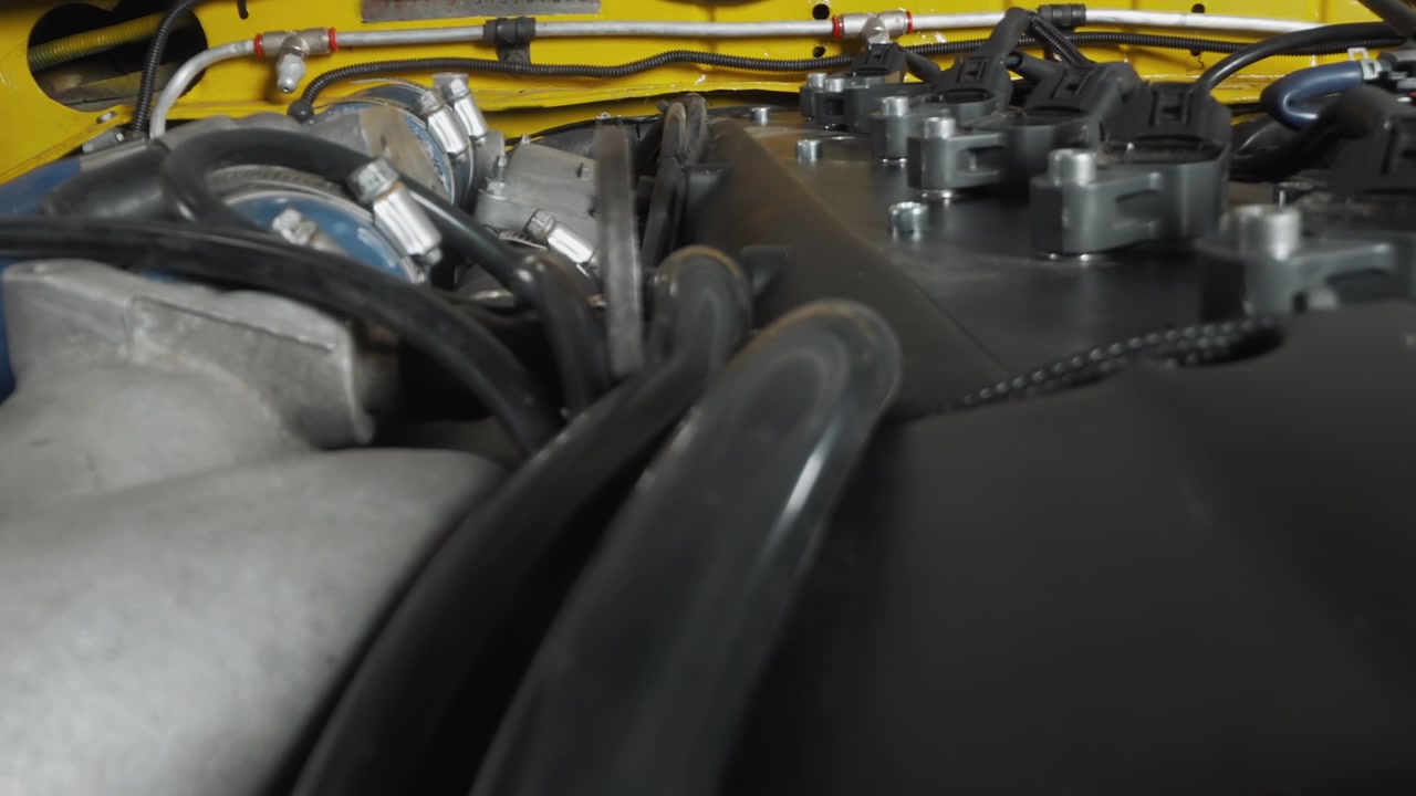 Detailed View of a Car Engine Bay with Hoses and Wires