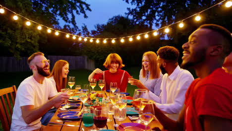 friends toasting with drinks at an outdoor dinner party