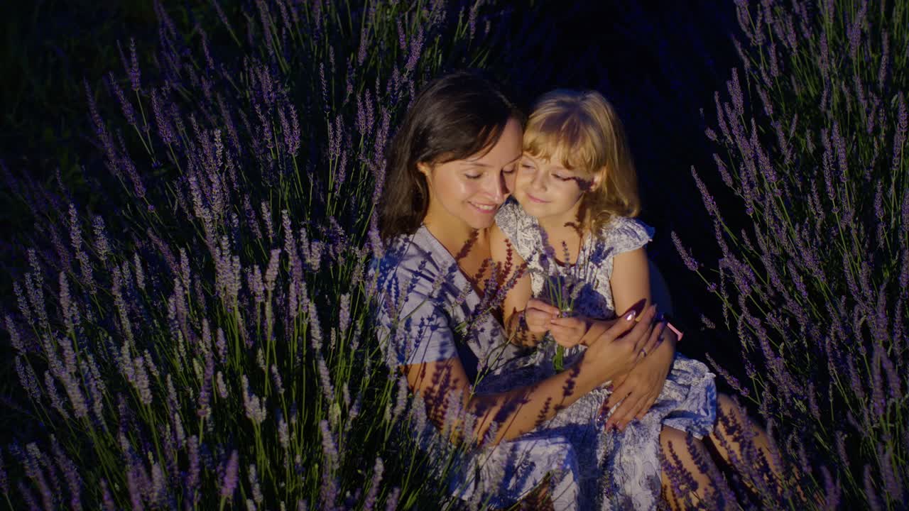 Mor og datter kysser og ler i en aromatisk lavendelåker om natten.