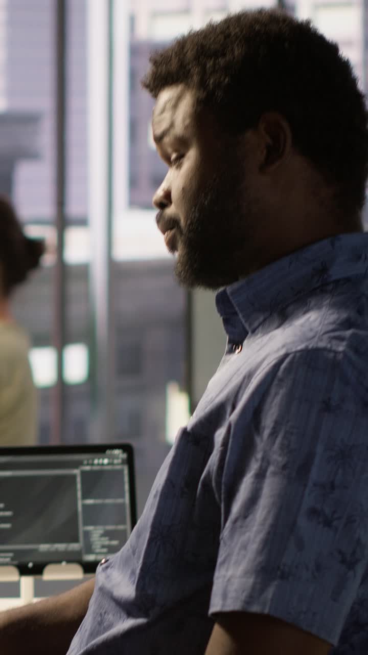 Vertical video Exhausted man being sleepy in workspace, programming on computer