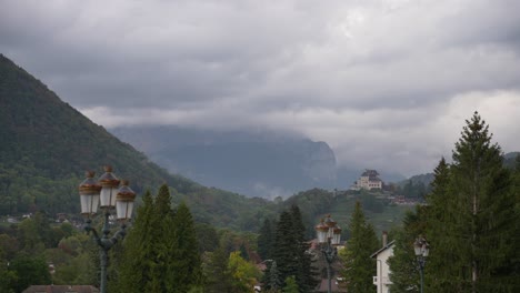 mont semnoz behind clouds seen from the town of annecy in the french alps, stable wide shot