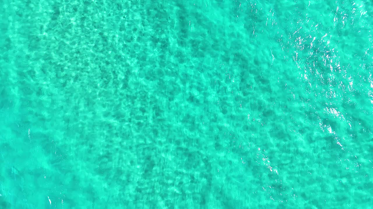 las olas turquesas del océano capturadas en la cabeza de los dedos