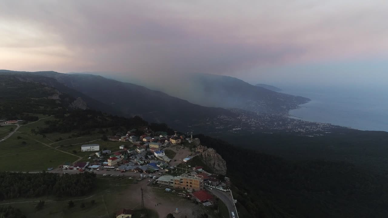 pueblo de montaña al atardecer con vista a la costa