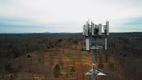 disparo aéreo inverso de una torre de teléfono celular rodeada de bosque