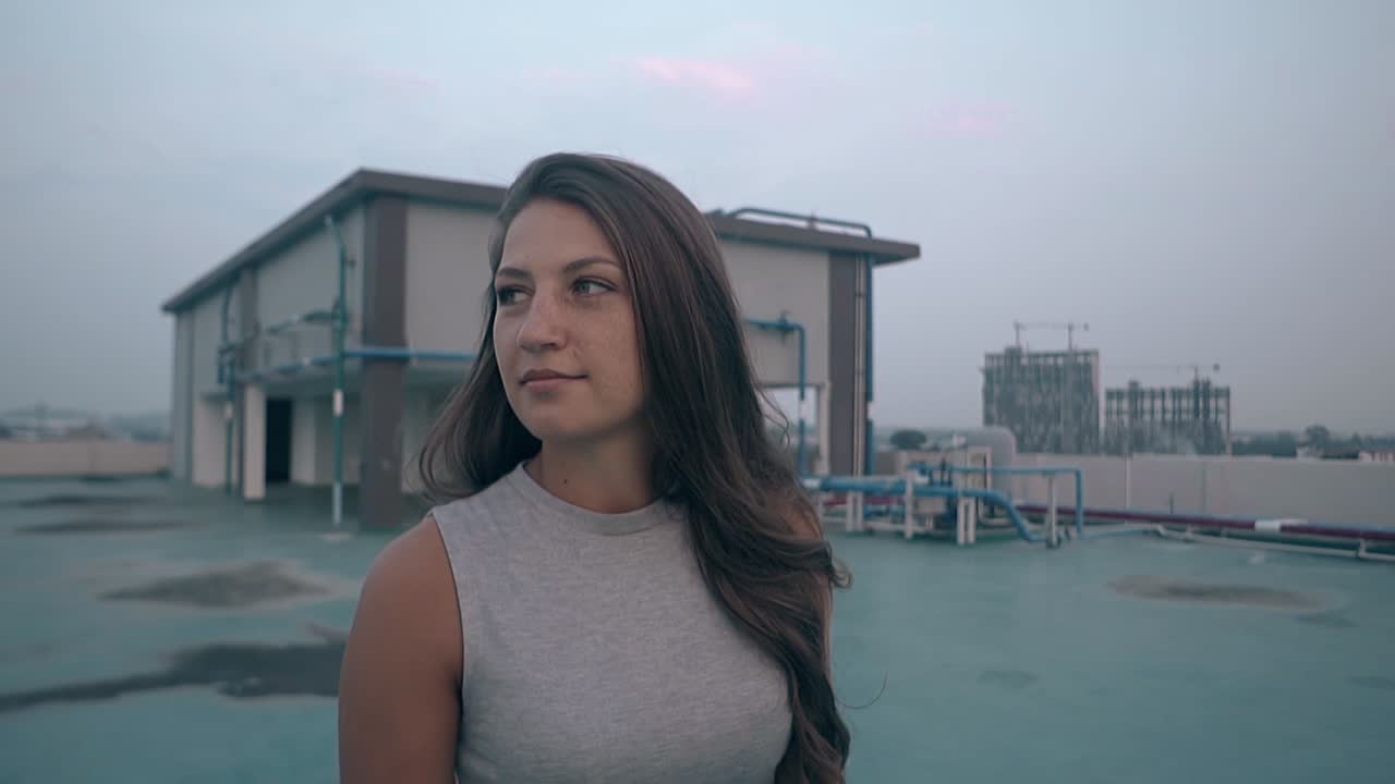 una bella donna con i capelli sciolti cammina lungo il tetto al rallentatore