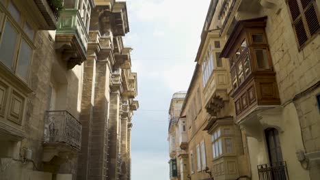 Tilt-down-from-balconies-in-narrow-street-of-Valletta,-Malta's-capital-city