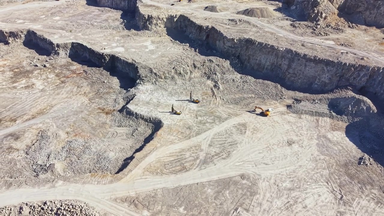 Granite quarry operation with heavy machinery in action during daylight