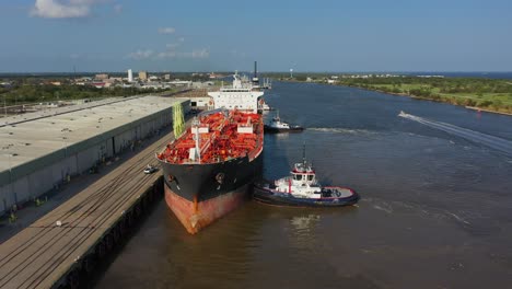 merchant ship docking assisted by a pilot and tug boat at port arthur port texas