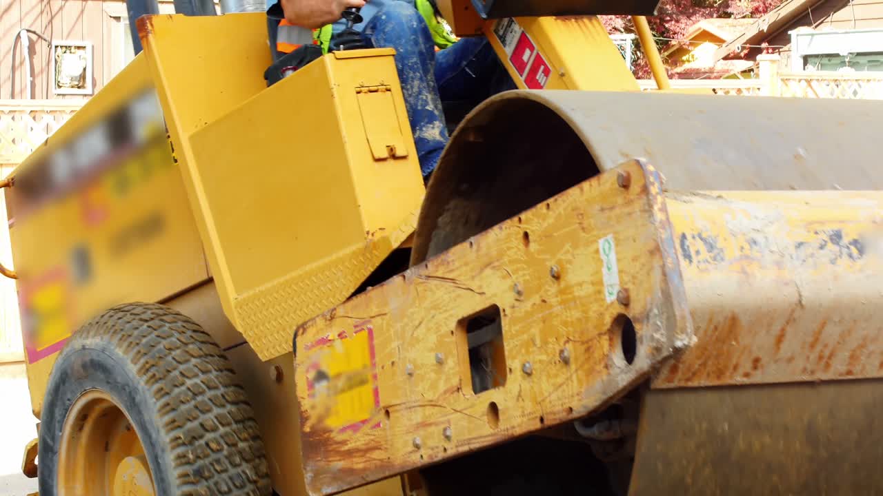 ingeniero nivelando el suelo con un rodillo de carretera