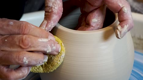 Close-up-of-the-potter's-hand-shaping-and-molding-clay-on-a-turning-wheel-