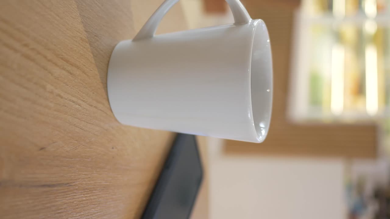 Hvit kaffekopp på trebord