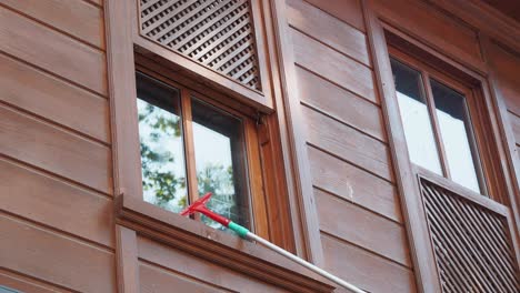 cleaning windows on a wooden building