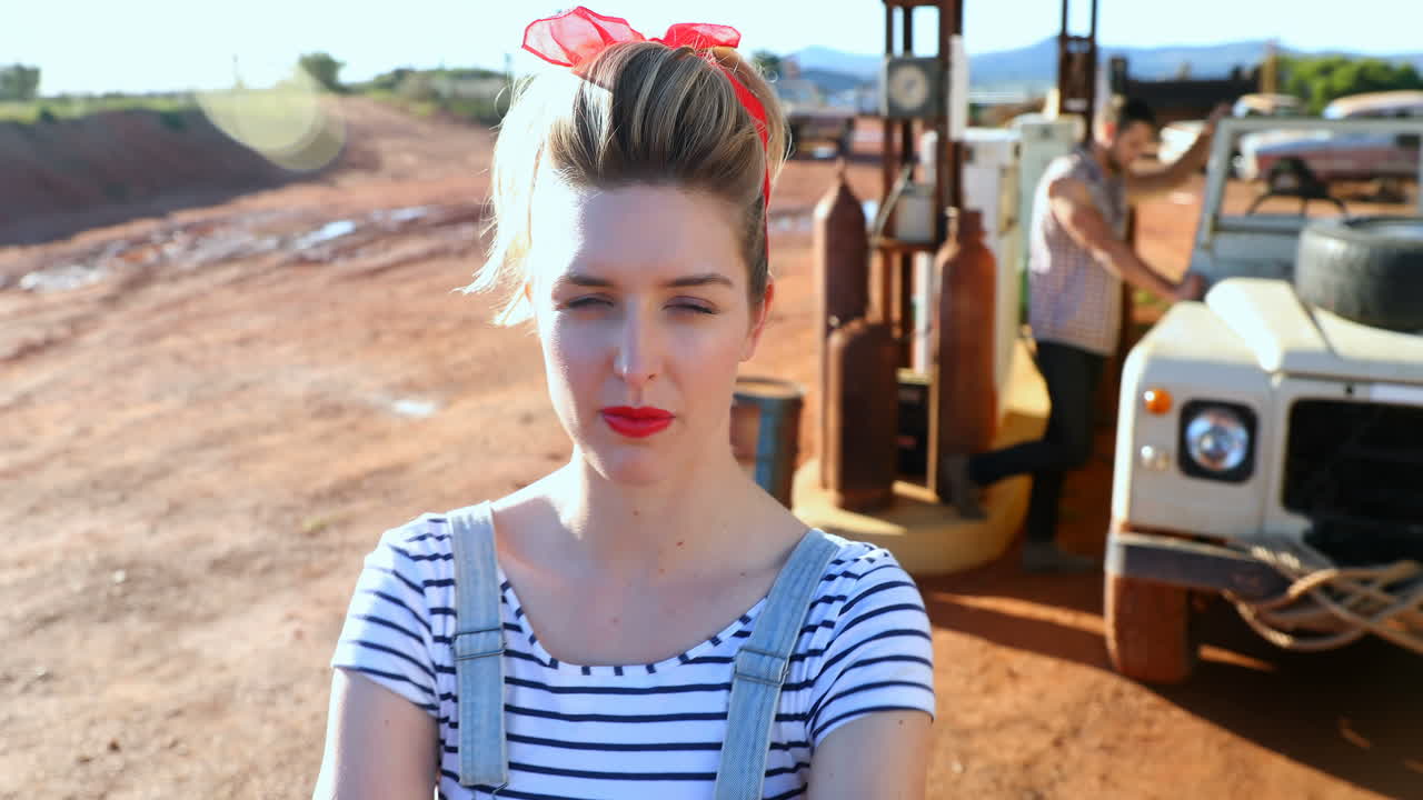 주유소 4k에 있는 차 근처에 서 있는 여자